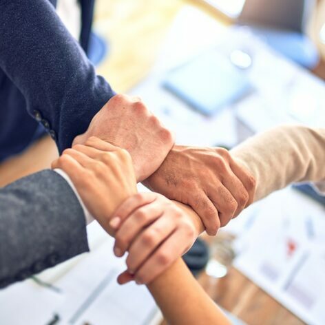 Strong team committed to collaborative success. Showing arms linked together. #teamwork #collaboration #unity #aboutus